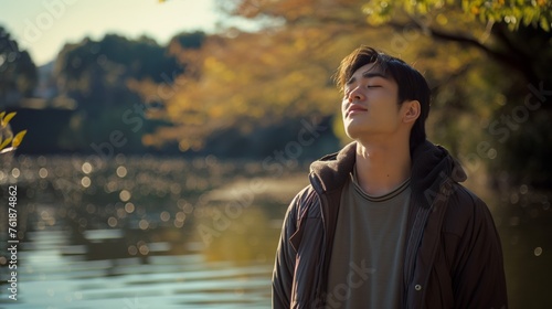 Fototapeta Naklejka Na Ścianę i Meble -  Asian young man enjoying the outdoors in nature. happiness in a beautiful outdoor portrait.