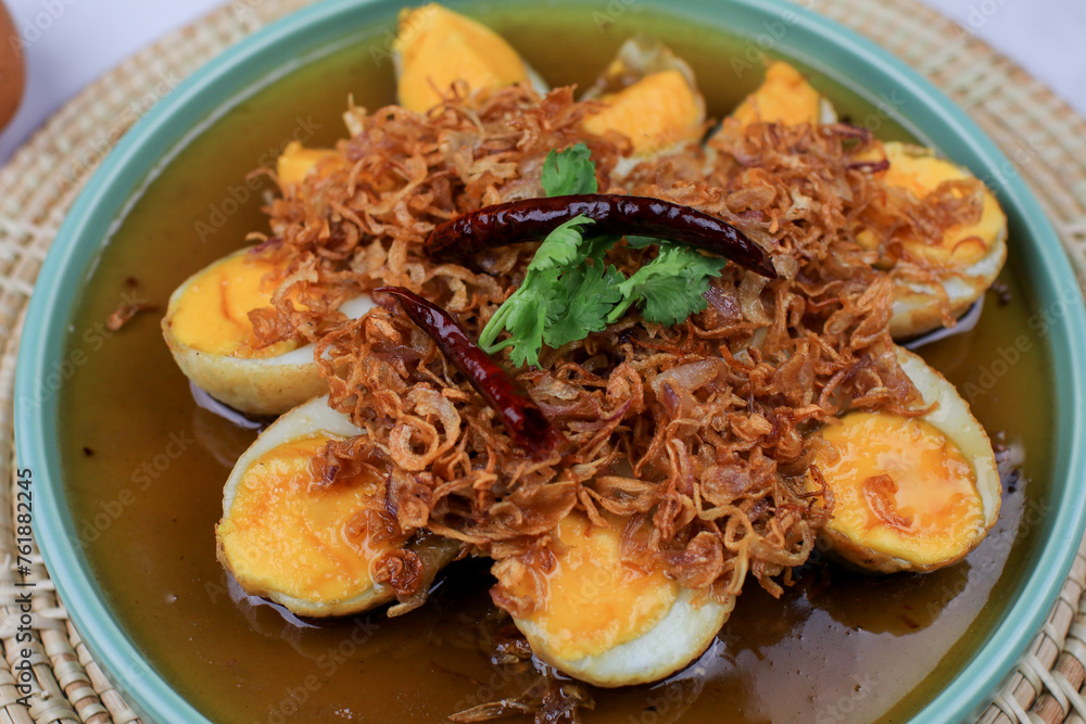Fried boiled egg with tamarind sauce topped with fried garlic, red onion and cilantro. Thai Cuisine. Homemade food. Fried boiled egg with tamarind sauce topped with fried garlic, red onion and cilantro. Thai Cuisine. Homemade food.