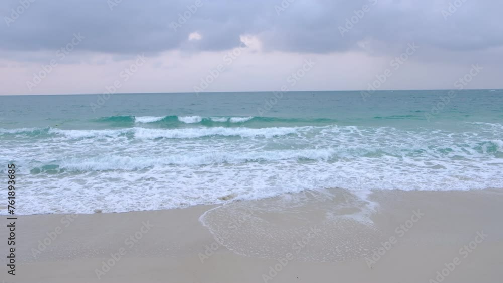 The sea had slight waves hitting the sand and creating white foam. The sea had slight waves hitting the sand and creating white foam.