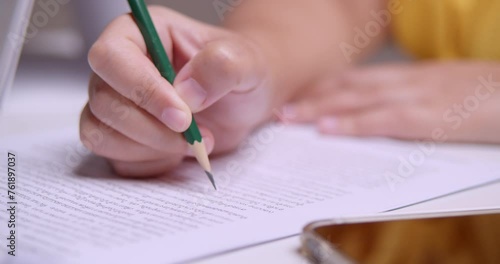 Close-up of an individual circling some words while thoroughly checking every detail for the final proofreading of a written article.