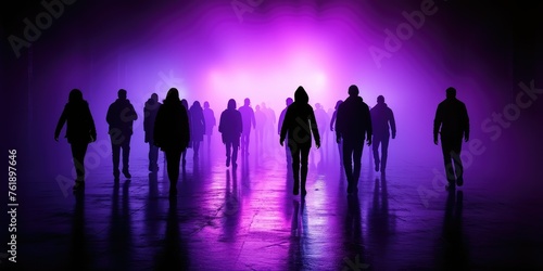 A group of people walking in darkness in front of a mesmerizing purple light
