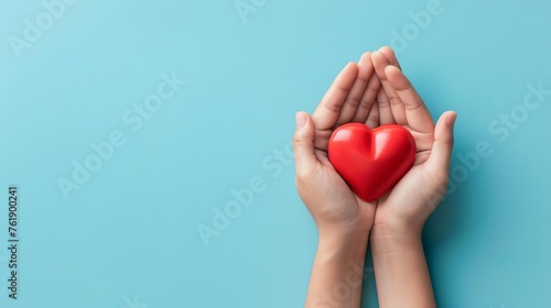Hands Holding Red Heart on Blue Background, Love and Compassion Concept