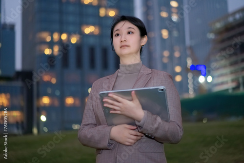 Young Businesswoman with Tablet in Urban Evening
