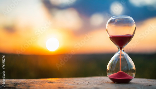 Hourglass on sunset backdrop symbolizing fleeting time, life's value, and urgency
