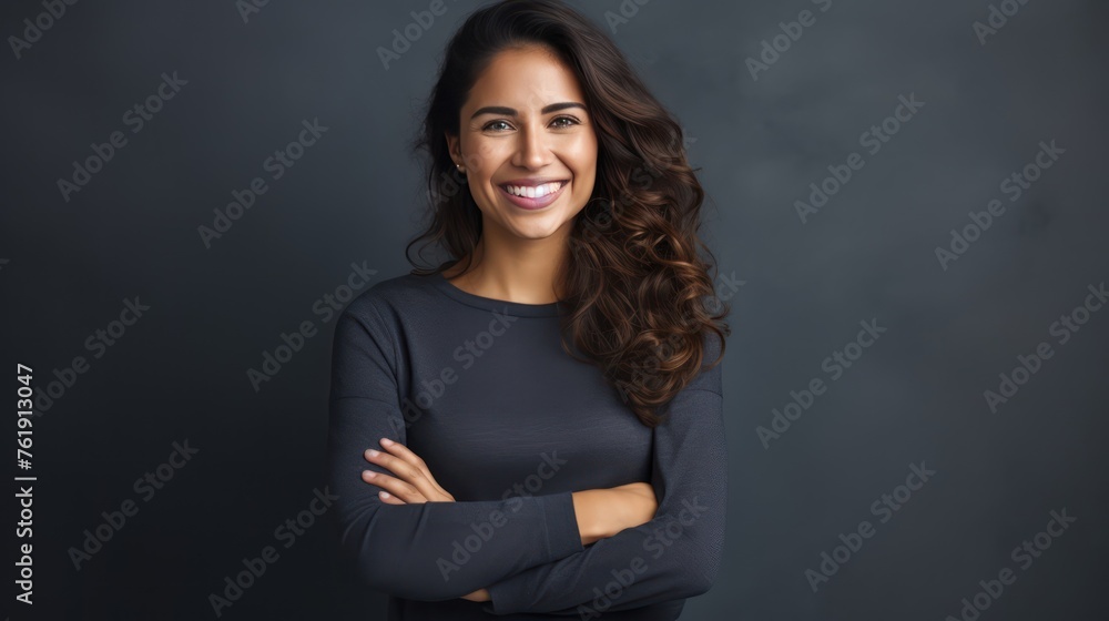 Portrait of young Mexican woman with pleasant smile and arms crossed isolated on gray wall with copy space Beautiful young woman with folded arms looking at camera against gray wall. isolated studio Portrait of young Mexican woman with pleasant smile and arms crossed isolated on gray wall with copy space Beautiful young woman with folded arms looking at camera against gray wall. isolated studio