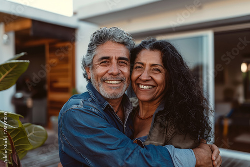 Joyful Senior Latino Couple Embracing in Front of Home
