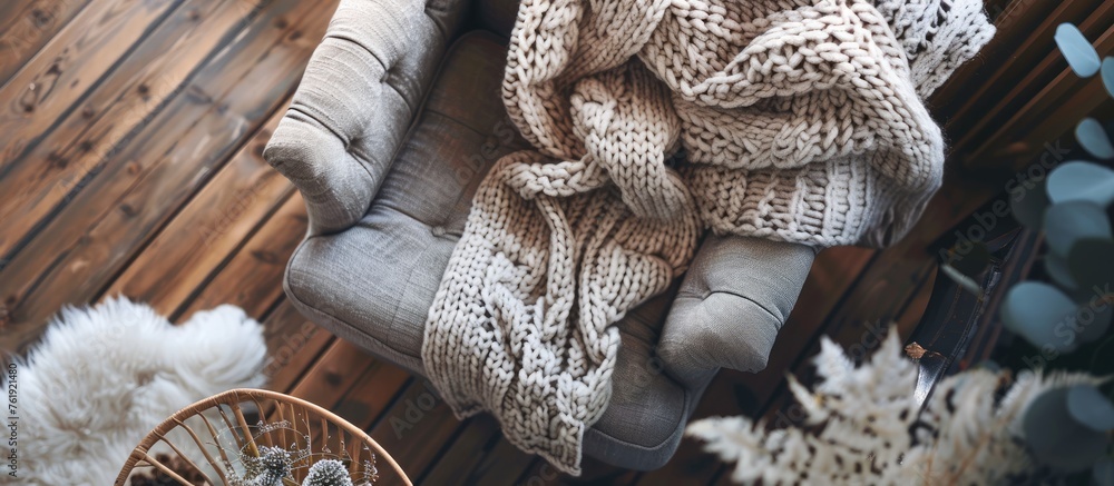 Knitted sweater on armchair in warm and cozy living room, top view