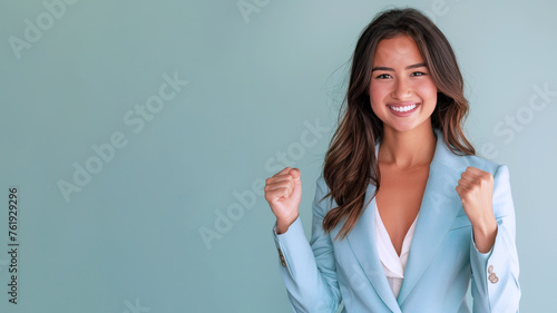 Indian businesswoman smiling in formal white blue suit clenched fist