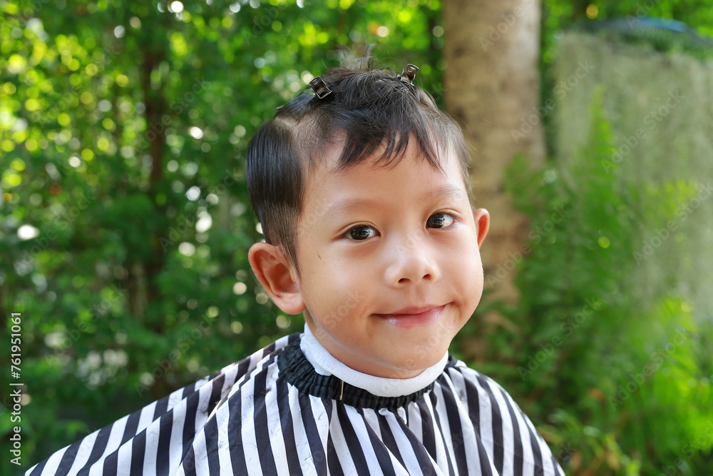 Cutting hair of Asian little boy with barber scissors in the garden. Cutting hair of Asian little boy with barber scissors in the garden.