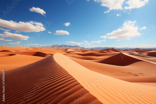 A desert landscape with sand dunes, mountains, and a clear blue sky