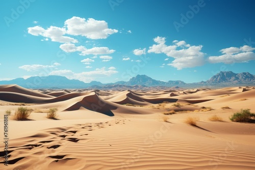 A natural landscape with sand dunes  mountains  and cumulus clouds in the sky