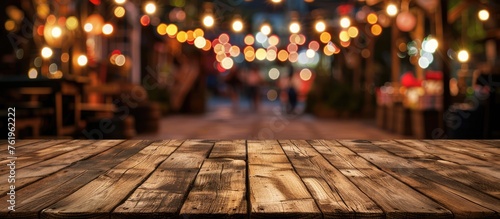 Night market background with empty wooden table top for product display. © Vusal