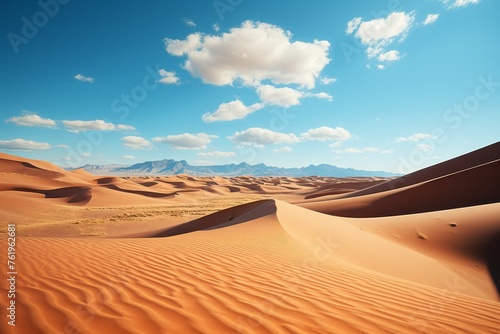 A natural landscape with sand dunes  mountains  and a cloudy sky