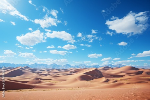 Natural landscape with dunes, mountains, and cumulus clouds against a blue sky