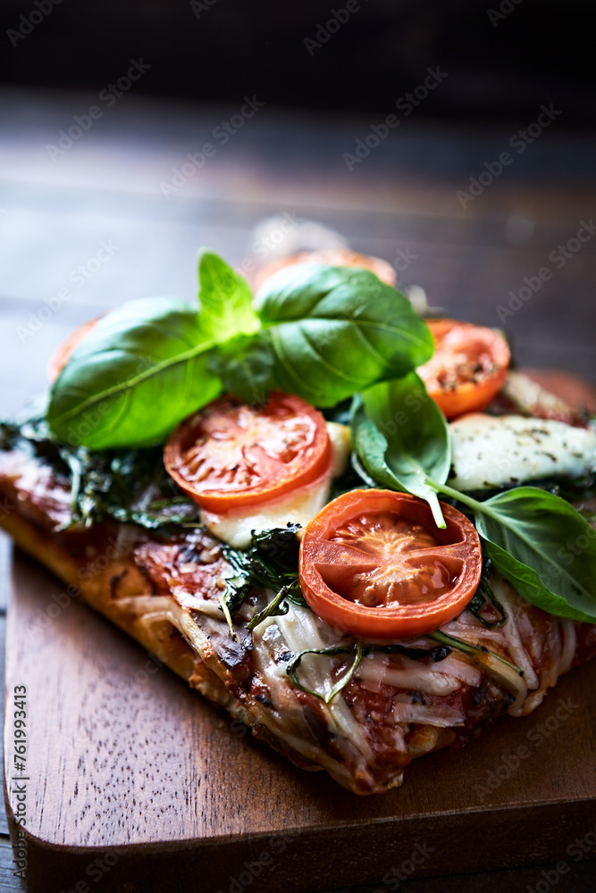 Open-faced toasted cheese sandwich with cherry tomatoes, spinach and fresh basil. Brown wooden background.	