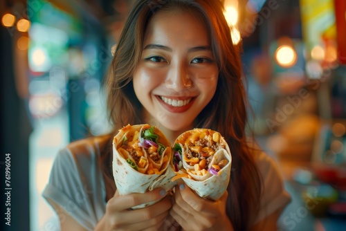 Smiling Young Woman Holding Delicious Chicken Wraps in a Cozy Restaurant Setting  Enjoying a Tasty Meal