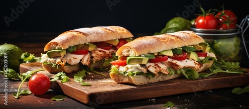 Chicken salad sandwich with lettuce and tomatoes on white plate
