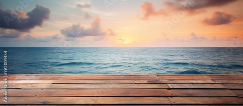 Wooden planks placed on sandy beach with sun setting in the horizon photo