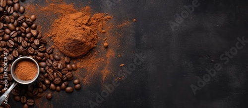 A spoon filled with coffee beans and ground beside a heap of coffee beans