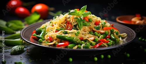 Pasta and veggies with herbs on black background