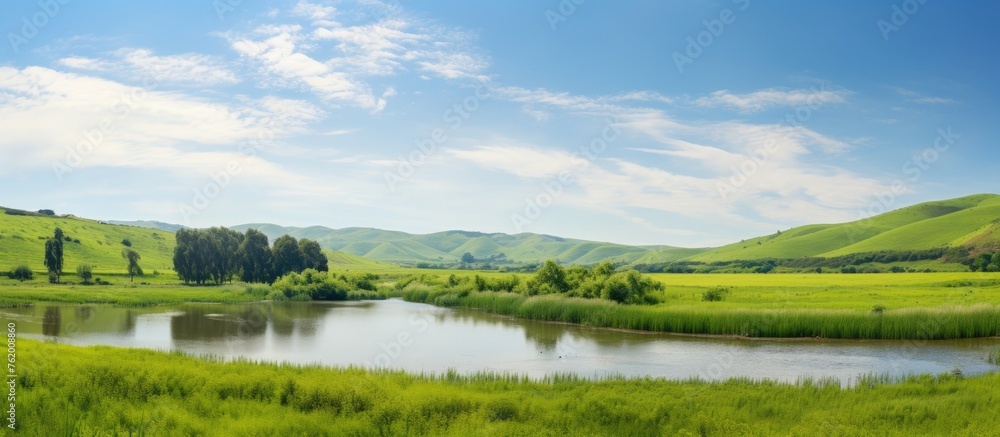 Fototapeta premium Lake surrounded by lush hills and forest