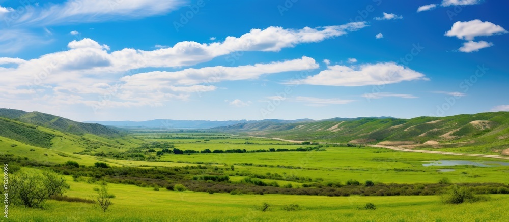 A serene river flowing through a lush green valley A serene river flowing through a lush green valley