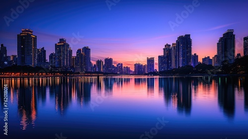 An elegant evening city skyline, lights reflecting on a calm river, skyscrapers silhouetted against a twilight sky, capturing urban beauty. Resplendent. © Summit Art Creations