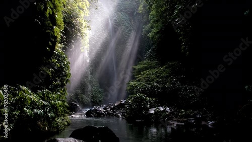 Tripod footage of sun beams in a reain forest nearby Hidden waterfall. Sekumpul, Bali, Indonesia. photo