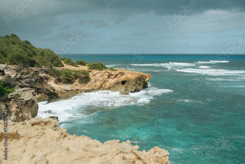 View of waves crashing on a rocky cliff on a stormy summer day on a tropical island