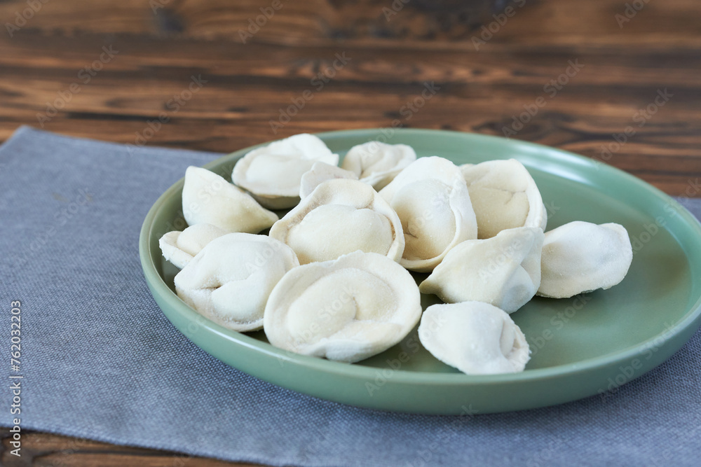 Meat dumplings on a green plate on a wooden background. Meat dumplings on a green plate on a wooden background.