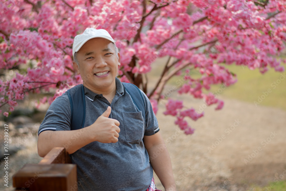 Asian middle-aged man in white cap and has backpack standing and ...