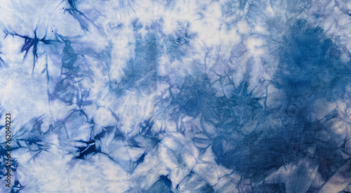 Close-up batik shirt with abstract indigo blue dye detail on white fabric cotton background on top-view