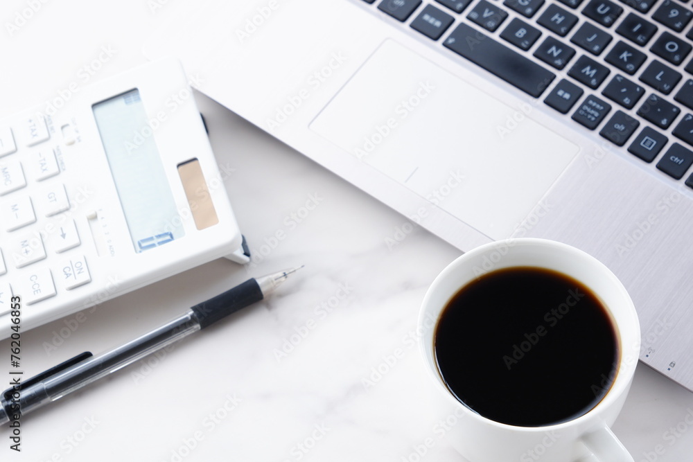 淹れたてのコーヒーを飲みながら、電卓とノートパソコンでデスクワークをしているイメージ
淹れたてのコーヒーを飲みながら、電卓とノートパソコンでデスクワークをしているイメージ