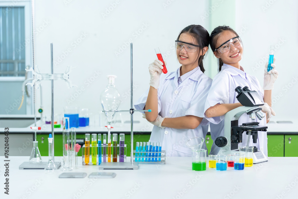 Two Asian scientists are doctors who produce COVID-19 medicines and vaccines in a biology lab. Use microscopes and beakers to conduct medical research and treat patients in hospitals. Two Asian scientists are doctors who produce COVID-19 medicines and vaccines in a biology lab. Use microscopes and beakers to conduct medical research and treat patients in hospitals.