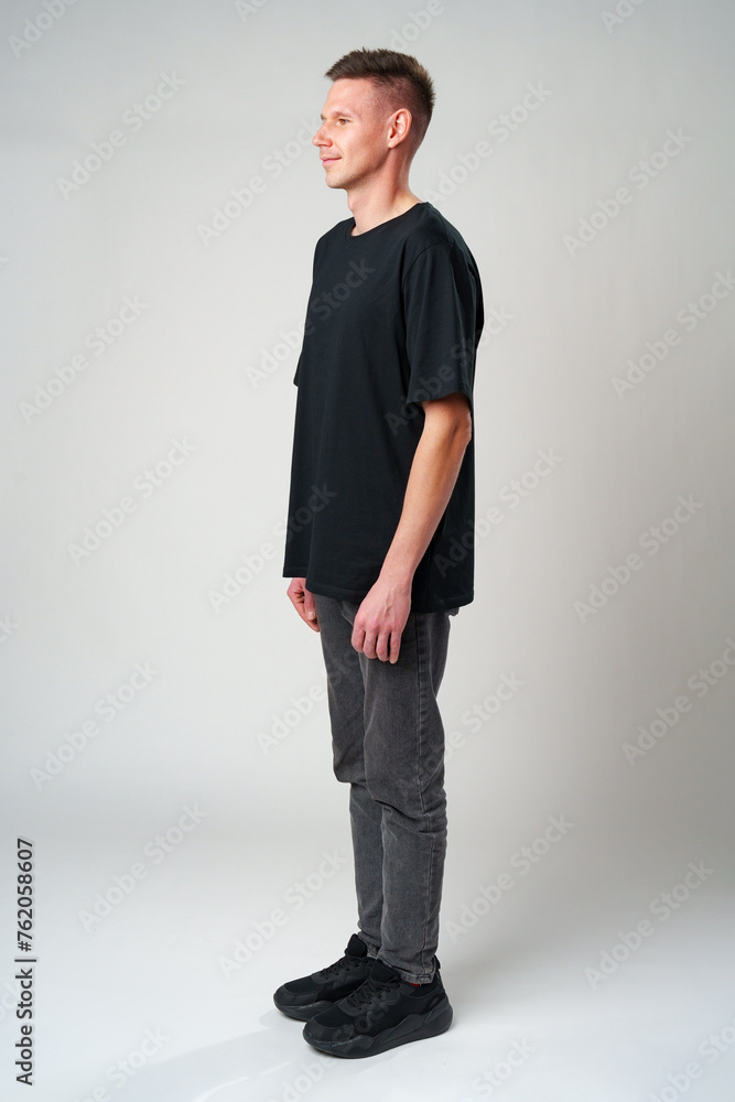 Full length portrait of young smiling man wearing casual clothes on gray background Full length portrait of young smiling man wearing casual clothes on gray background