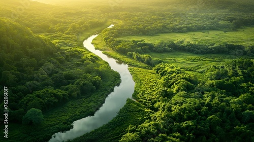 A winding river cutting through a lush green valley © Photock Agency