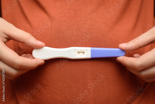 Woman is holding a pregnancy test in her hand.