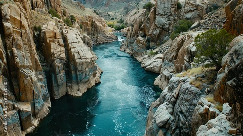 A tranquil river flowing through a canyon, carving its way through rugged cliffs