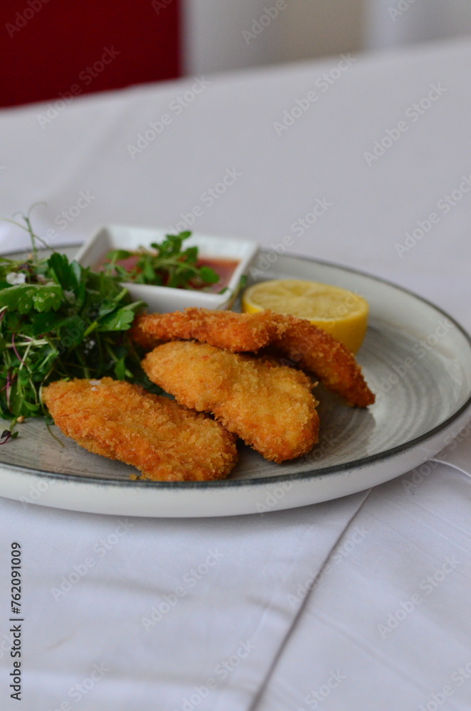 Wiener schnitzel with salad on a restaurant table. Wiener schnitzel with salad on a restaurant table.