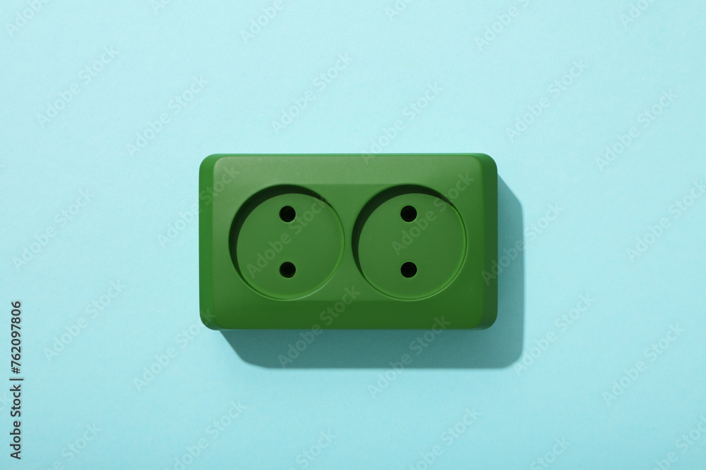 Green electric socket on a blue background Green electric socket on a blue background