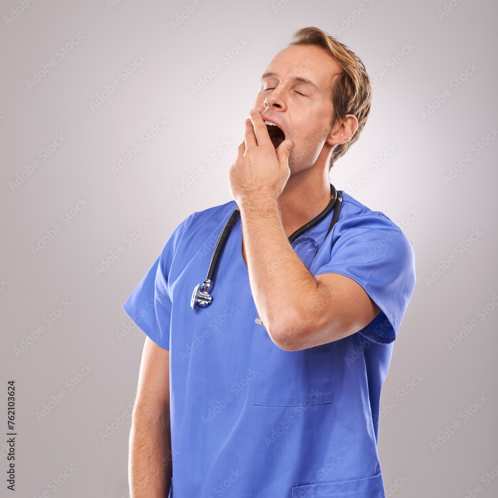Doctor, studio and yawn for overworked, tired and burnout with stethoscope for job. Man, specialist and stress for professional, medic and health care or medical pressure isolated on white background Doctor, studio and yawn for overworked, tired and burnout with stethoscope for job. Man, specialist and stress for professional, medic and health care or medical pressure isolated on white background