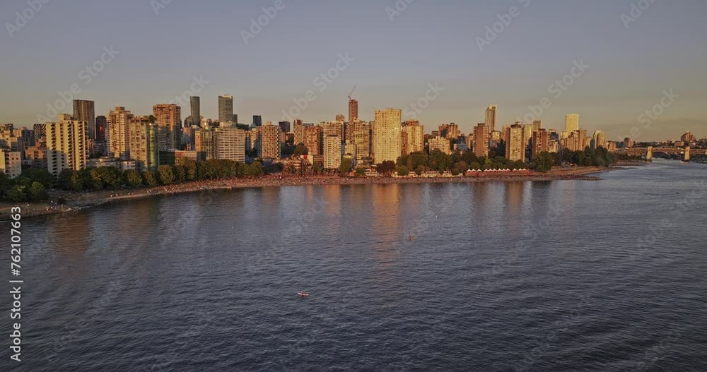 Vancouver BC Canada Aerial v59 drone flyover the water capturing crowds at popular English bay beach and seawall promenade, West End cityscape at sunset - Shot with Mavic 3 Pro Cine - July 2023