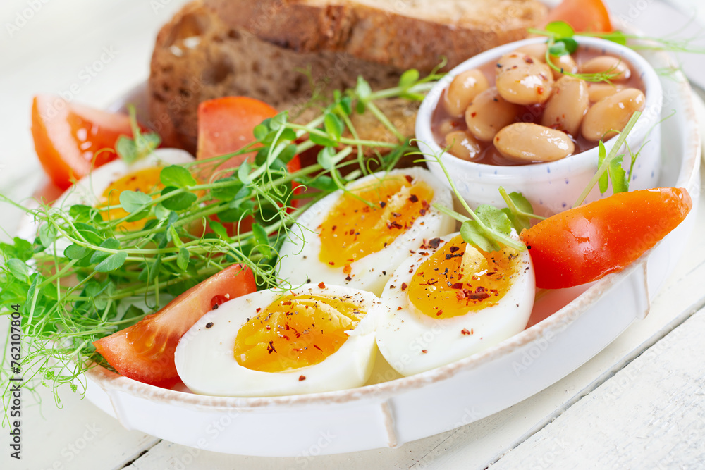 English breakfast. Boiled egg, beans, toast and green herbs. English breakfast. Boiled egg, beans, toast and green herbs.