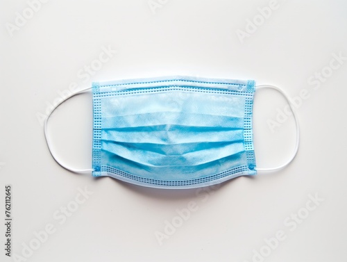 A single blue surgical mask isolated on a white background, symbolizing health safety and pandemic protection
