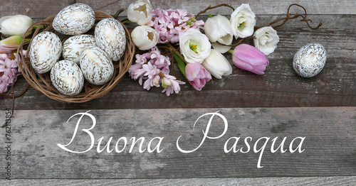Biglietto d'auguri Buona Pasqua: fiori e uova di Pasqua su fondo in legno con il testo Buona Pasqua. photo