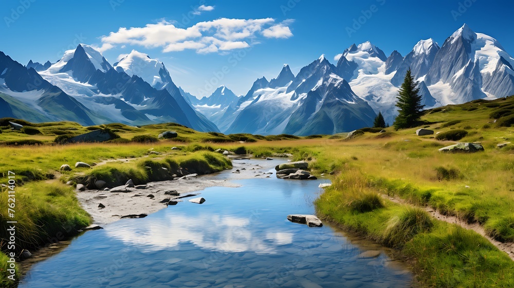  Beautiful mountain landscape with grassy meadow and clear stream in the foreground, Alps mountains on background.