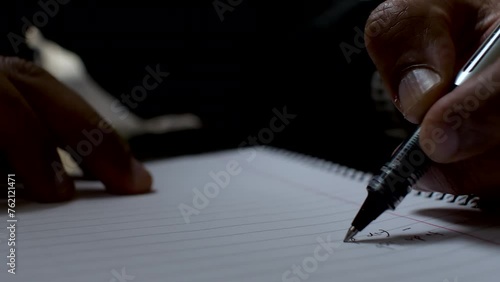Close-up of a person writing on paper using a pen, creating a list with their left hand, highlighting the unique perspective of left-handed writing. photo