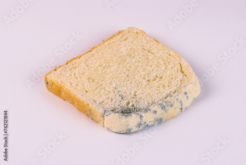 Moldy bread on a white background, closeup of photo