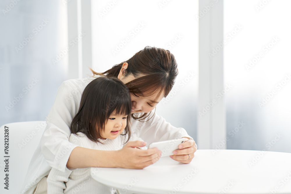 ママとスマホを見る女の子 ママとスマホを見る女の子