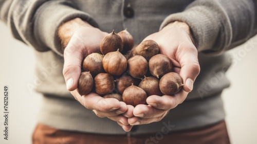 The gardener's hand holds a chestnut and lifts it upwards.